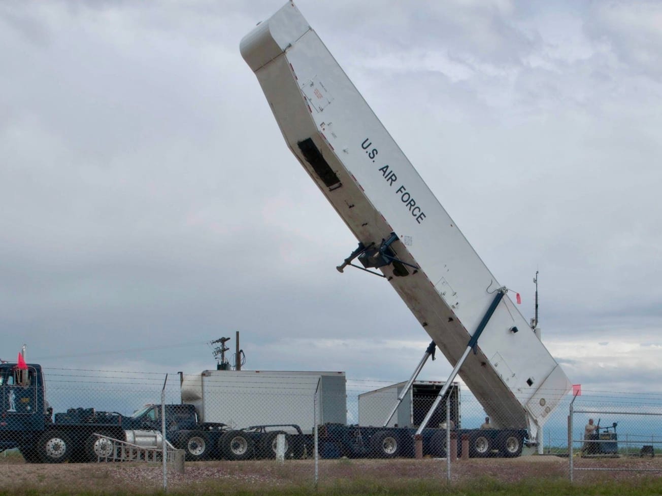 A U.S. Air Force transporter erector attached to a payload transporter is raised with the missile removed