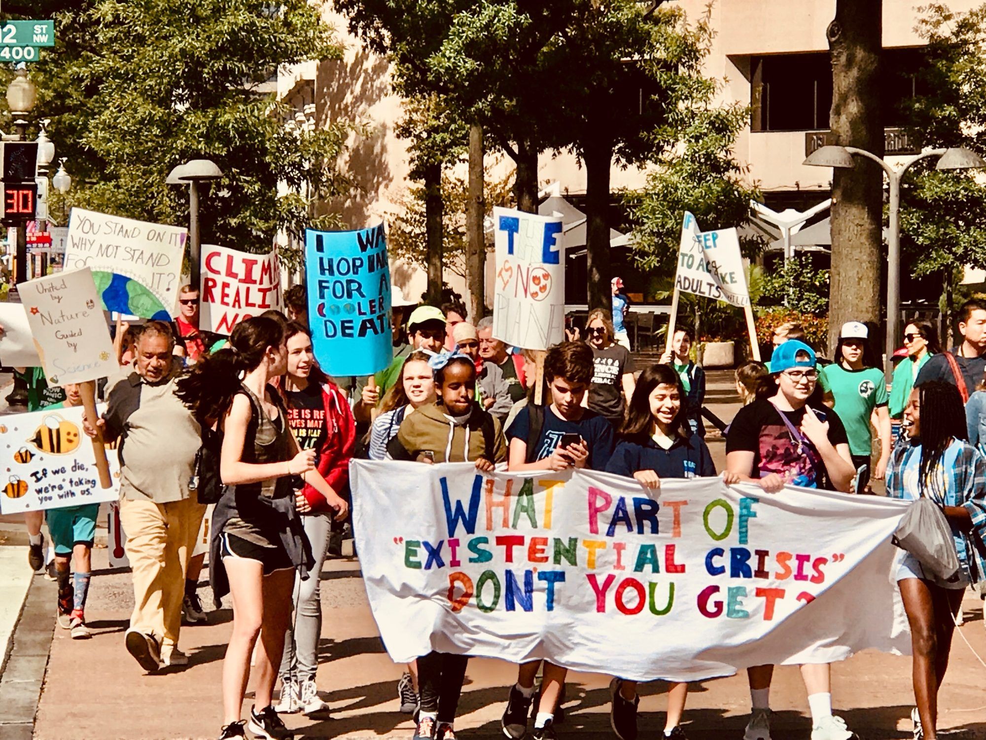 Student climate protesters walk on Pennsylvania Ave. past the Trump International Hotel in Washington